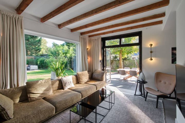 Woonkamer met loungebank en tuinzicht