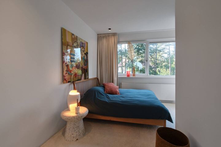Slaapkamer met tweepersoonsbed en tuinzicht